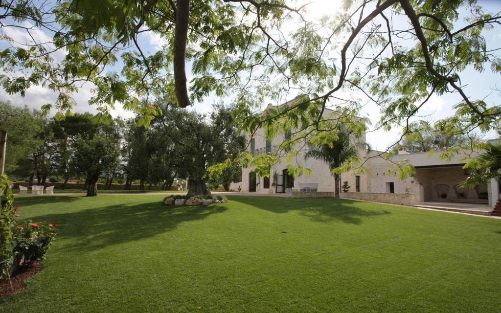 滨海波利尼亚诺Masseria Torre Catena Resort & Restaurant的一座带绿草大院子的房子
