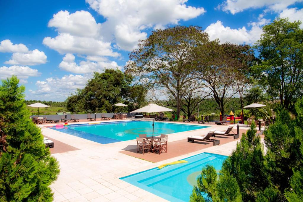 萨尔托德尔瓜7萨尔托斯度假酒店的一个带桌椅和遮阳伞的游泳池
