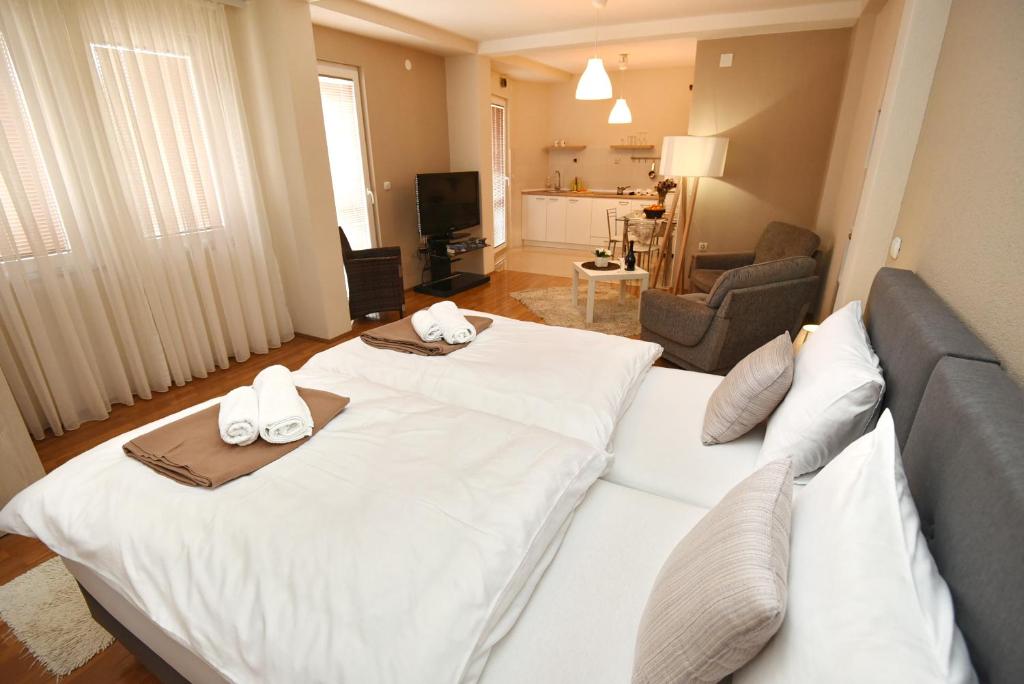 奥赫里德Villa Mishe的酒店客房设有一张白色大床和一间客厅。