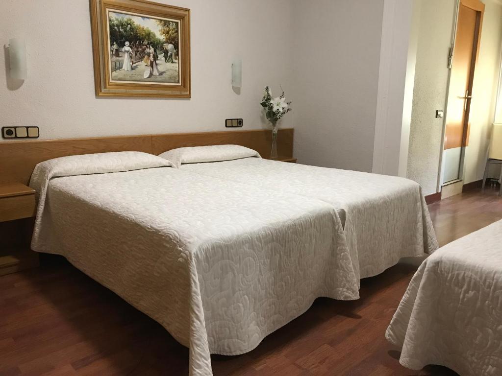 巴塞罗那佩拉约酒店的卧室配有两张床,墙上挂着一幅画