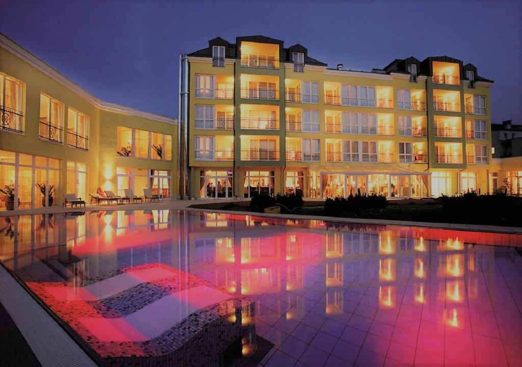 巴特斯哈尔巴赫公园酒店的一座大型建筑,前面设有一个游泳池