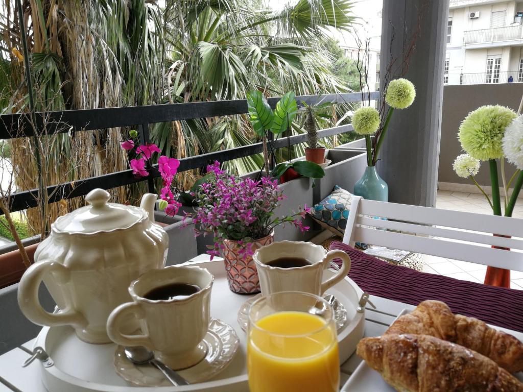 卡利亚里Cagliari Family Apartment的桌子,带两杯咖啡和茶壶