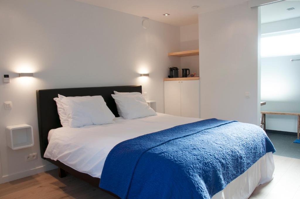 克诺克－海斯特阿奎维特住宿加早餐酒店的一间卧室配有一张带蓝色毯子的床