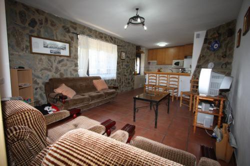 Solana de ávilaCasa Rural el Huerto的带沙发和桌子的客厅以及厨房。