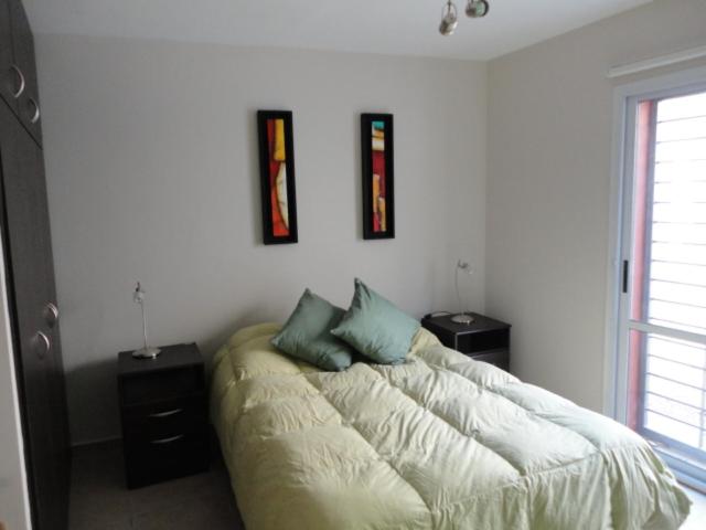 圣胡安Complejo Temporario Las Marias的一间卧室配有带2个床头柜和1扇窗户的床