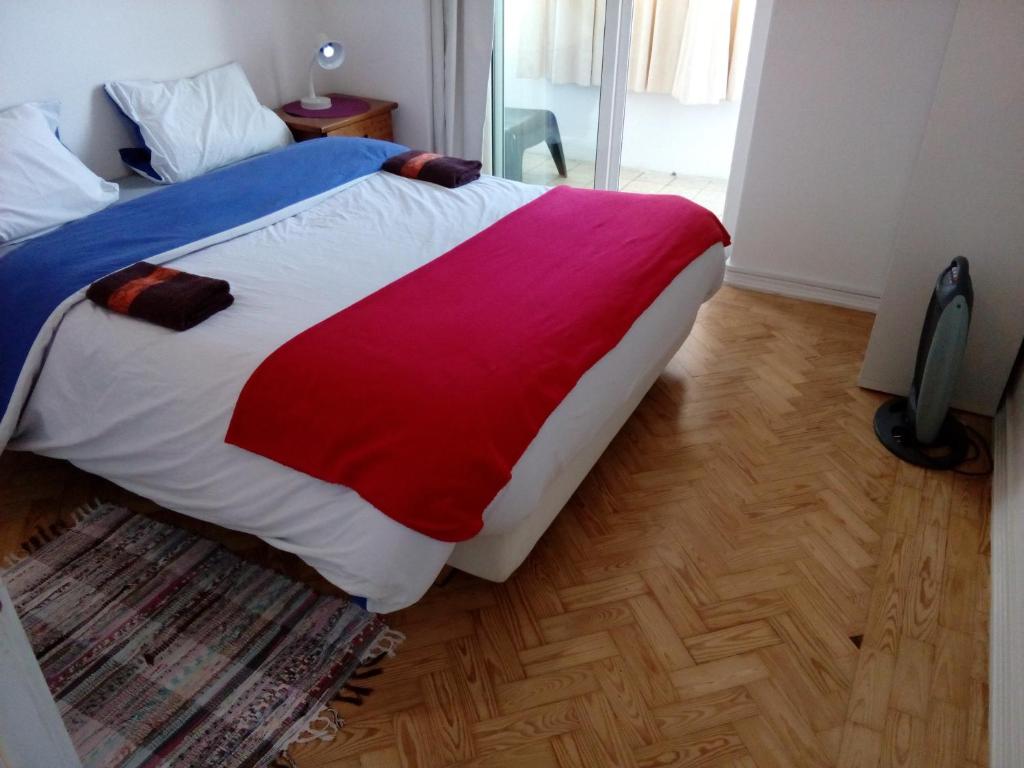 里斯本Voyage 63的一间卧室配有一张带红色白色和蓝色毯子的床