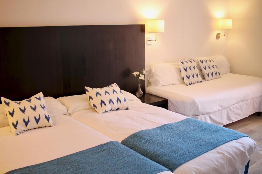 帕尔马诺瓦贾克顿旅馆的酒店客房带两张带蓝白色枕头的床