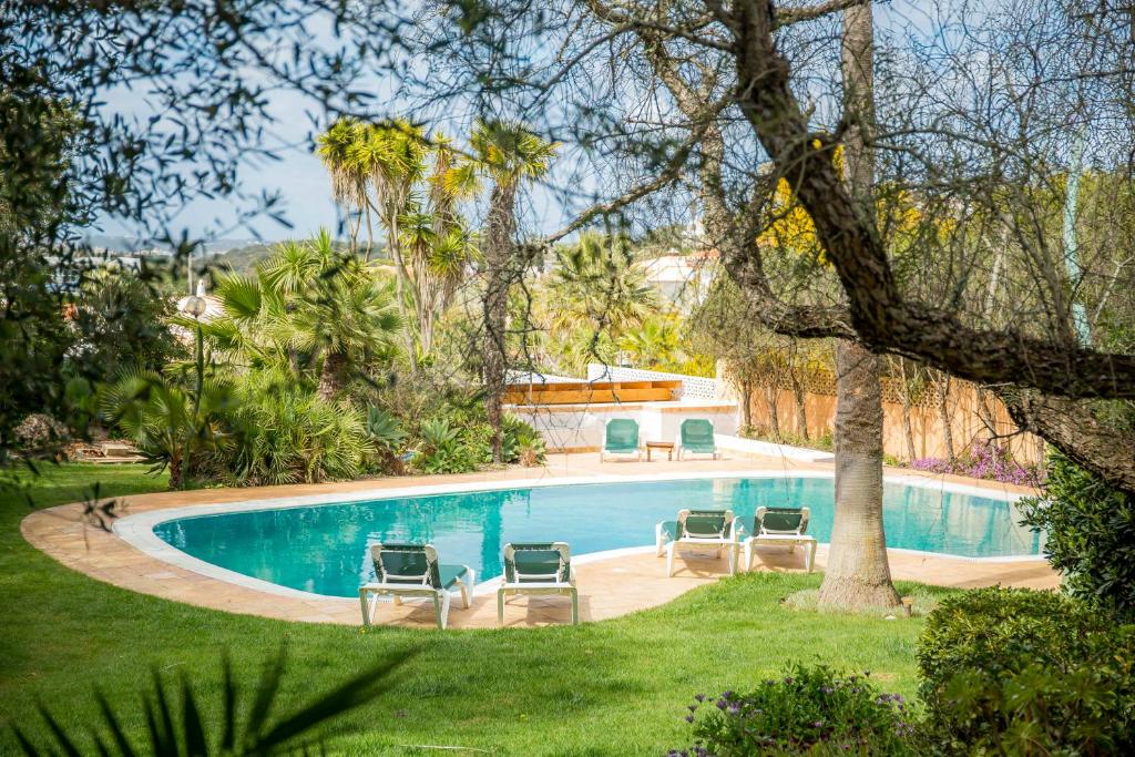 卢斯Casa da Montanha的庭院内一个带四把躺椅的游泳池