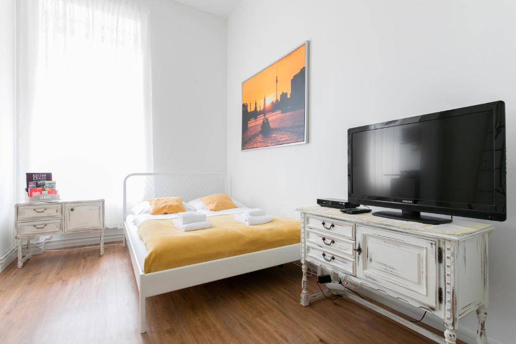 柏林City Studio Apartment in Friedrichshain的卧室配有带床铺的梳妆台,配有电视