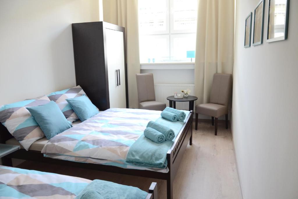 布拉迪斯拉发布拉迪斯拉发旅舍的一间卧室配有两张带蓝色枕头的床