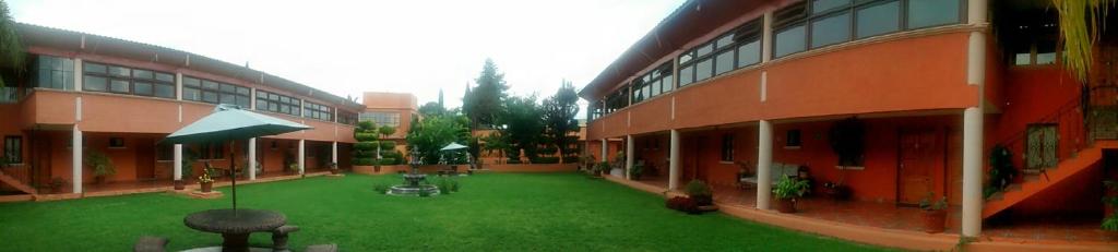 圣胡安特奥蒂瓦坎特奥蒂奥铃酒店的一座带绿色草坪的建筑的庭院