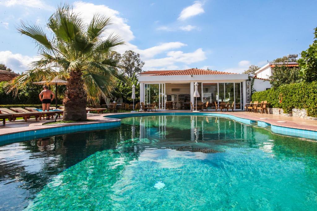 圣帕拉斯凯维奥斯特瑞亚公寓式酒店的一座棕榈树和房子的游泳池