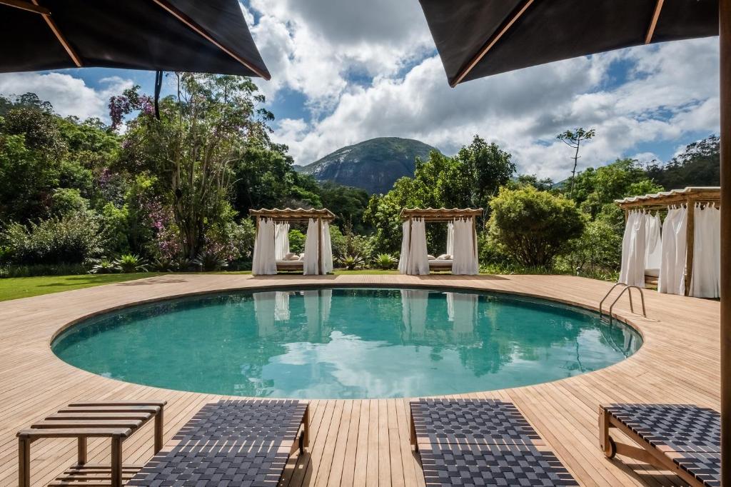 伊泰帕瓦坦卡玛拿旅馆的一个带甲板和椅子的游泳池以及一座山