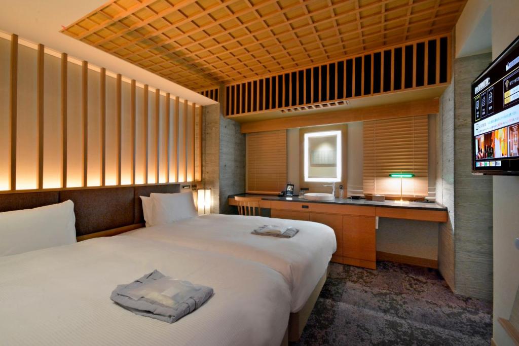 东京HOTEL HILLARYS Akasaka的酒店客房,配有床和电视