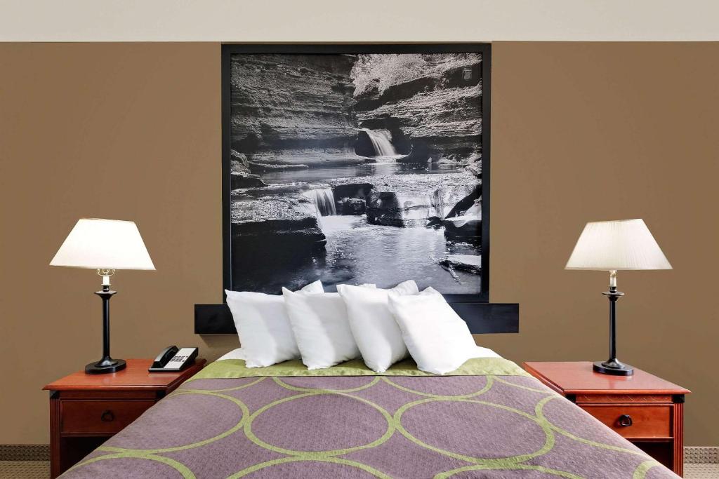 伊萨卡伊萨卡速8酒店的酒店客房,配有一张带两盏灯的床