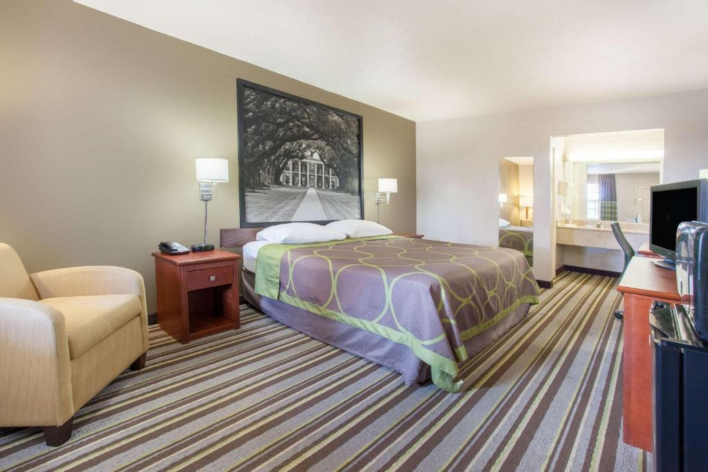 西门罗Super 8 by Wyndham West Monroe的酒店客房,配有床和沙发
