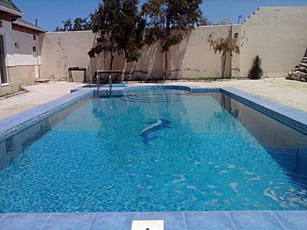 ŞüvǝlǝnShuvelan Cottage House的庭院里的一个蓝色海水游泳池