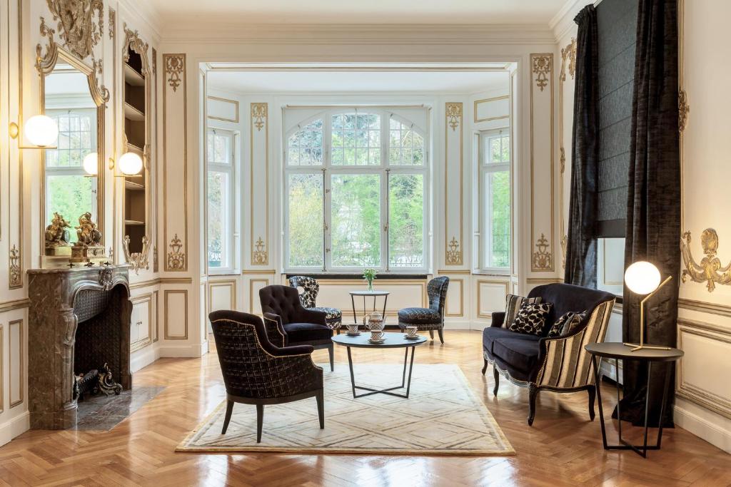 梅斯Villa Camoufle的客厅配有椅子、桌子和壁炉