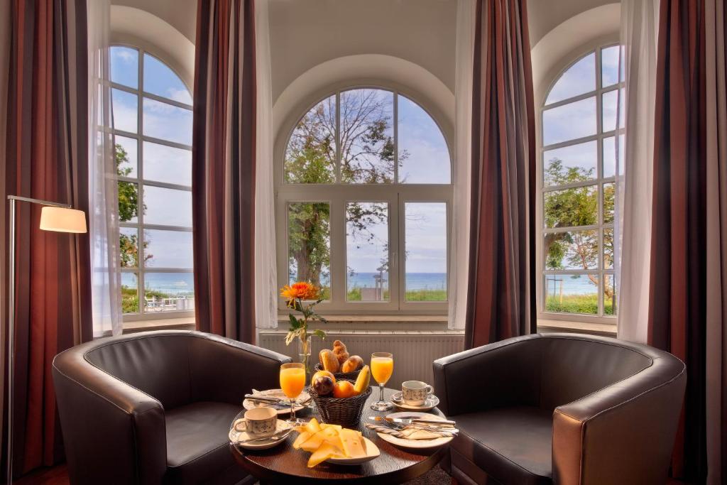 宾茨宾兹斯塔德酒店的用餐室配有两把椅子和一张带水果的桌子