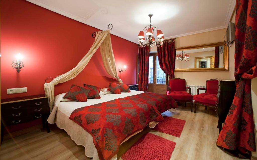 拉瓜迪亚Legado de Ugarte, Casa Rural的红色的卧室设有床铺和红色的墙壁