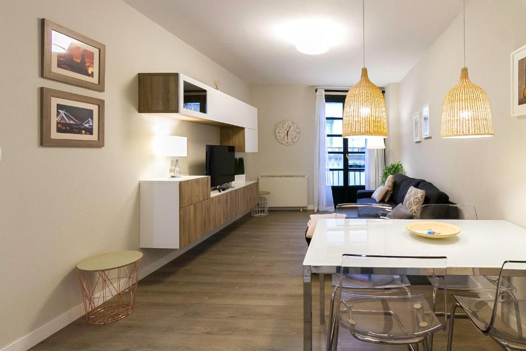 奥伦塞Céntrico Burgas Termal的一间带桌子的客厅和一间带沙发的客厅