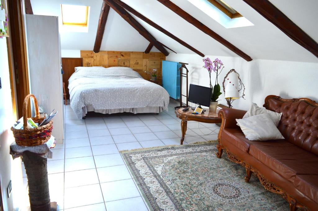 阿尔巴Il Nottetempo的一间卧室配有一张床和一个沙发