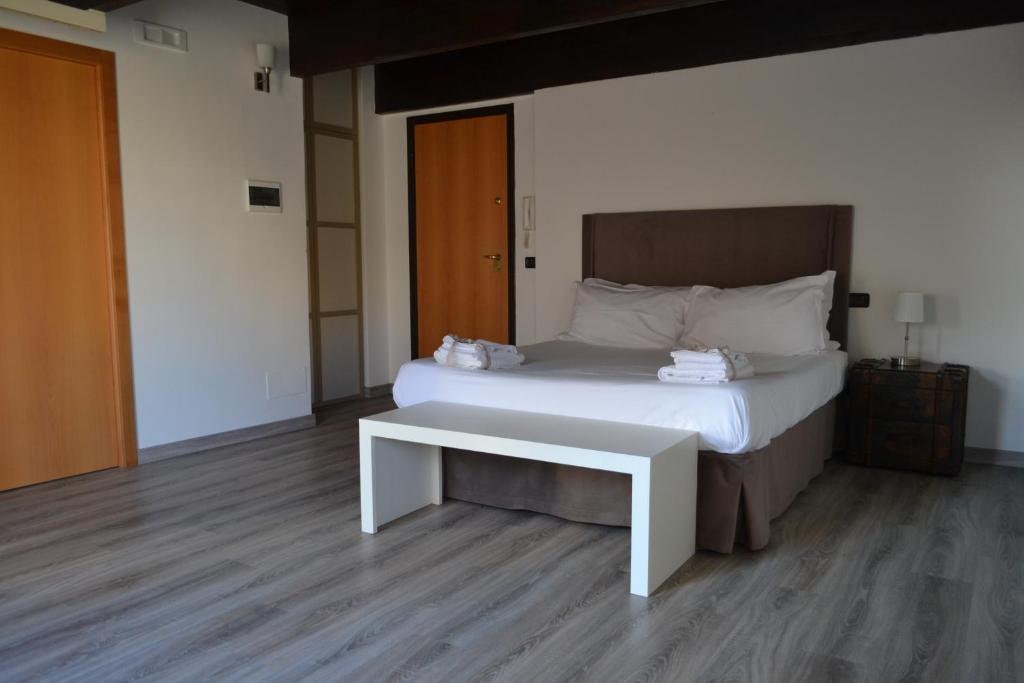 巴里Gatto Bianco le Dimore的卧室配有白色的床和长凳