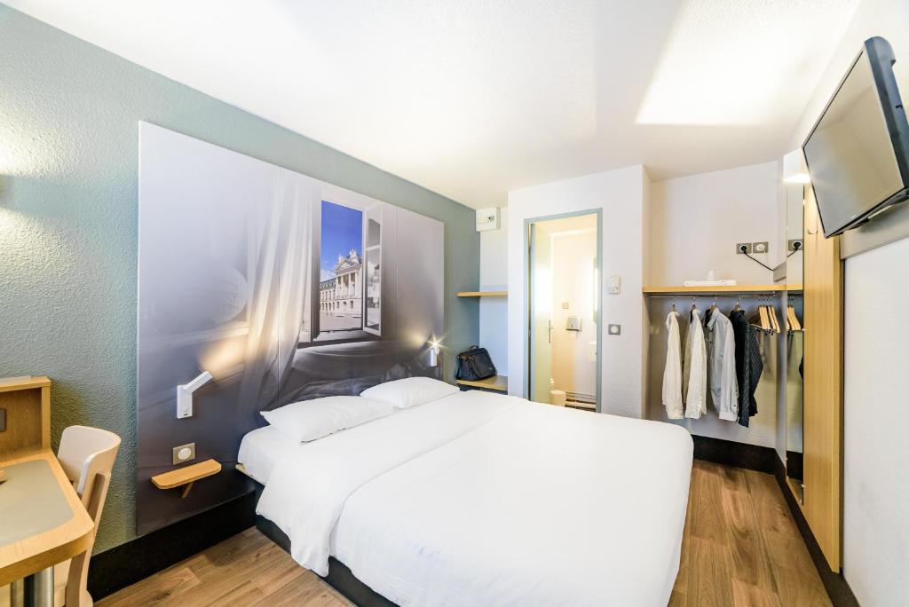 第戎B&B HOTEL Dijon Marsannay的卧室配有一张白色大床和一个衣柜