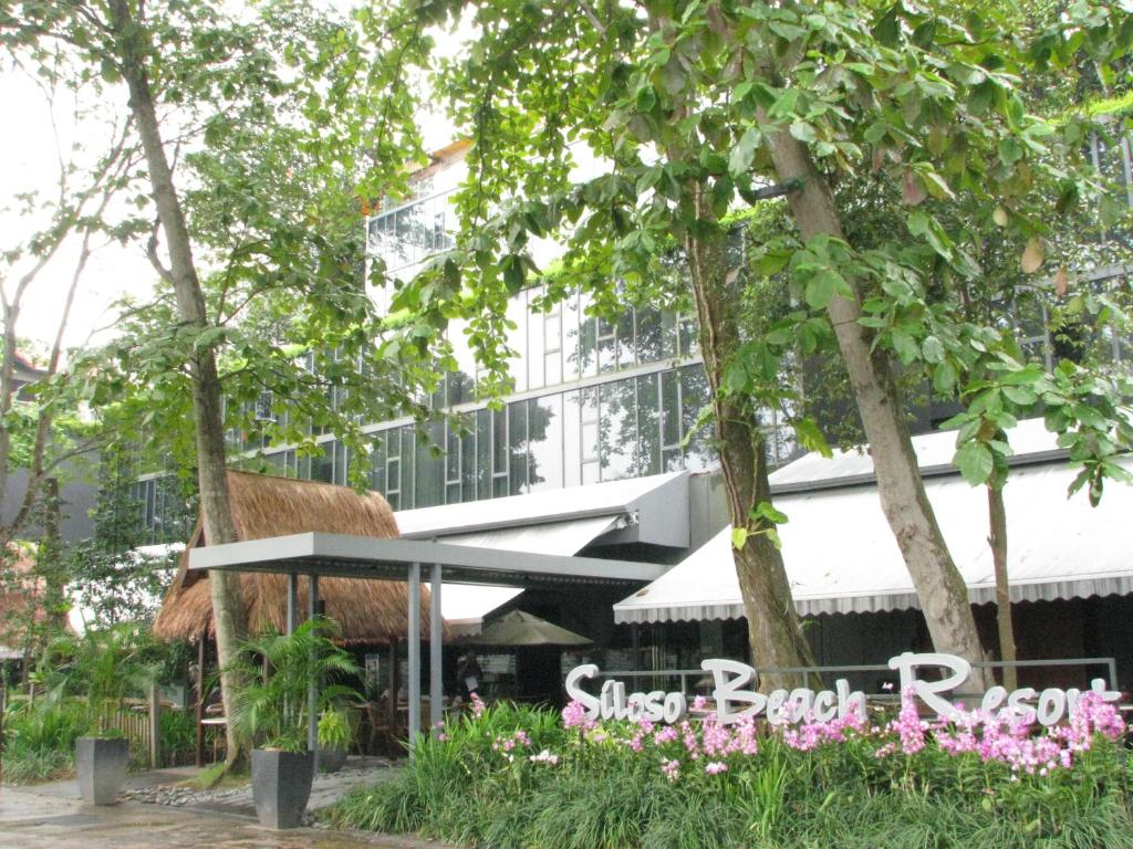 新加坡Siloso Beach Resort - Sentosa的享有带草地屋顶餐厅的建筑景致