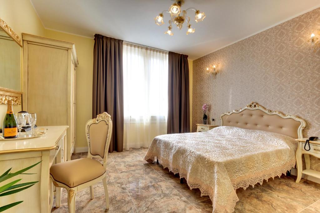 威尼斯丽都New Reiter Hotel的卧室配有1张床、1张桌子和1把椅子