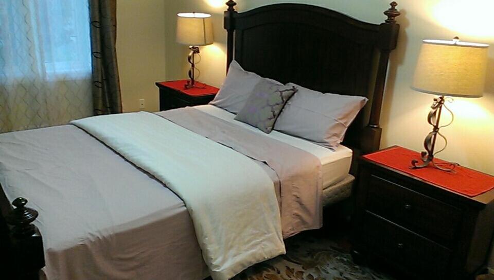 滑铁卢HB Guest Home 4的一间卧室配有一张大床,桌子上放着两盏灯