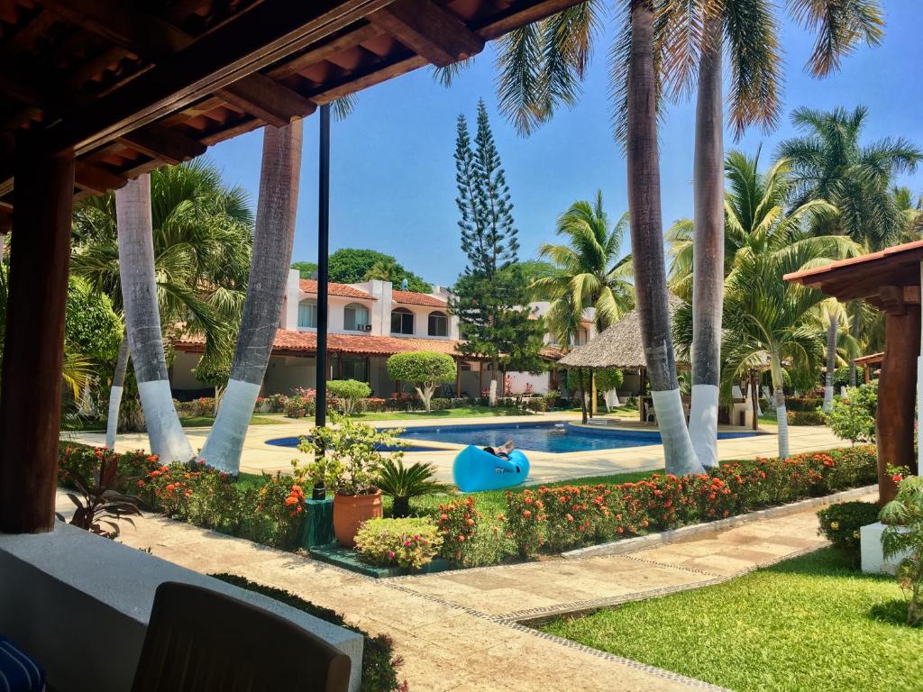 伊斯塔帕Casa Romantica De Playa的一个带游泳池和棕榈树的度假村