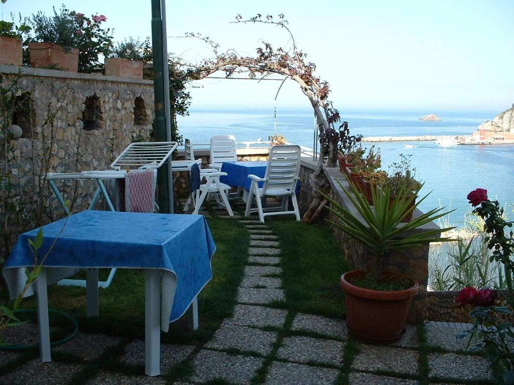 蓬扎L'Isolana Case Vacanza Palma 1的一个带桌椅的庭院和大海