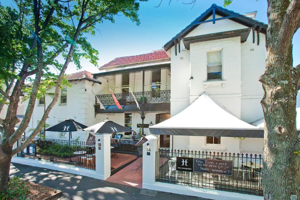 悉尼恒达精品酒店的前面有雨伞的白色建筑