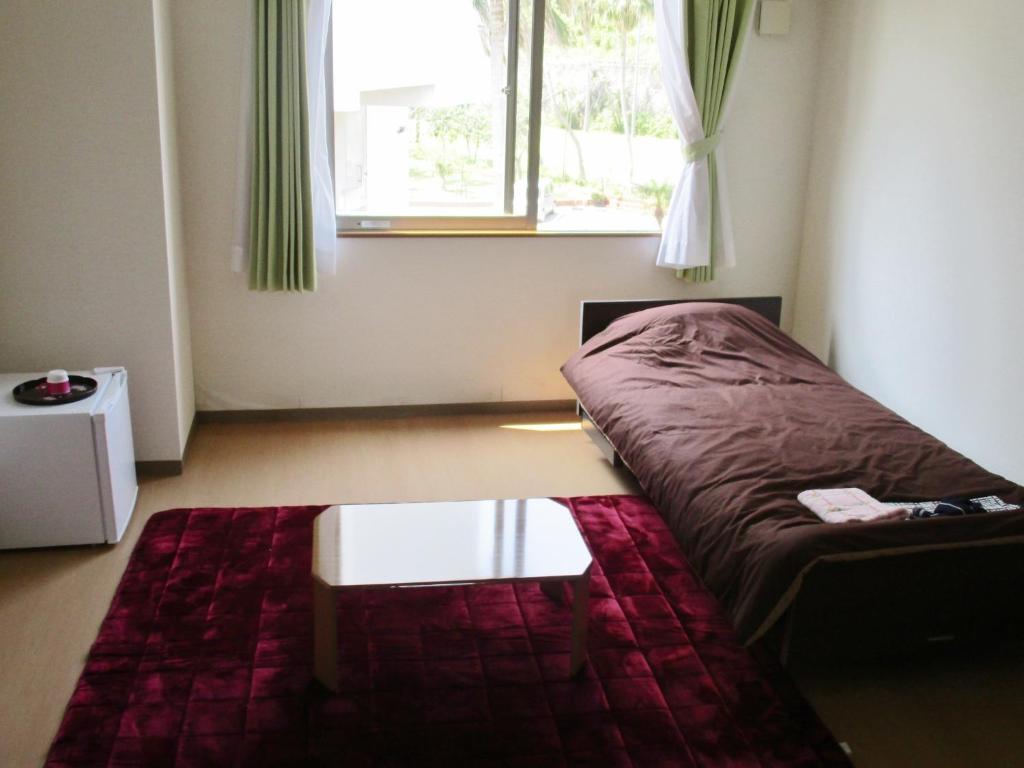 指宿市山彦御宿日式旅馆的客房设有床、桌子和窗户。