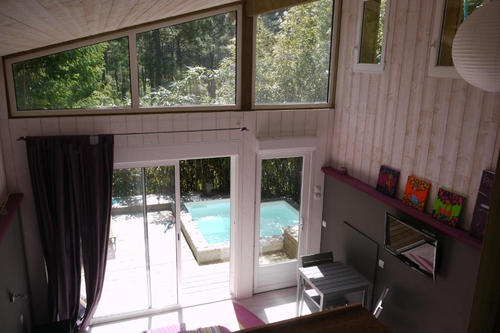 拉卡诺奥肯Un Matin D’été的享有带游泳池和窗户的房子的景色