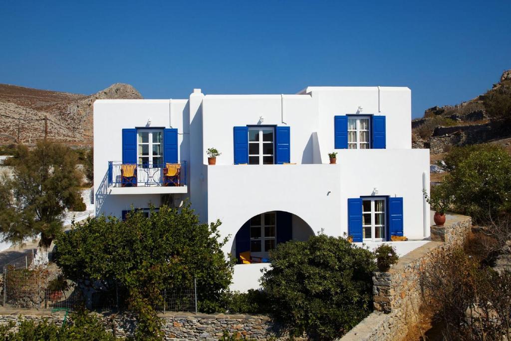 阿莫尔戈斯全景酒店的山坡上带蓝色窗户的白色房屋