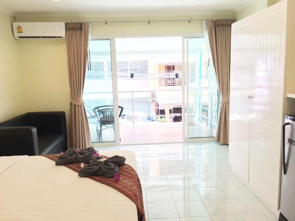 乔木提恩海滩泰国兰花经济型酒店的一间卧室设有一张床,享有阳台的景色