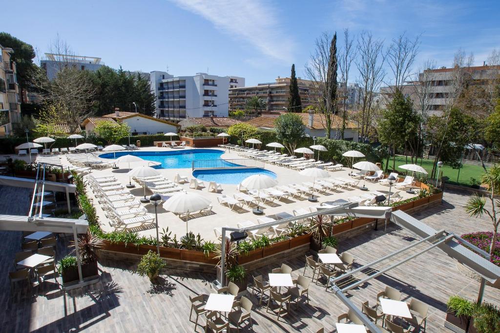 萨洛斯艾度假中心公寓式酒店的一个带白色椅子和遮阳伞的室外游泳池