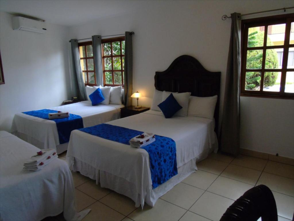 马那瓜Hotel Los Pinos的酒店客房带两张床和两个窗户