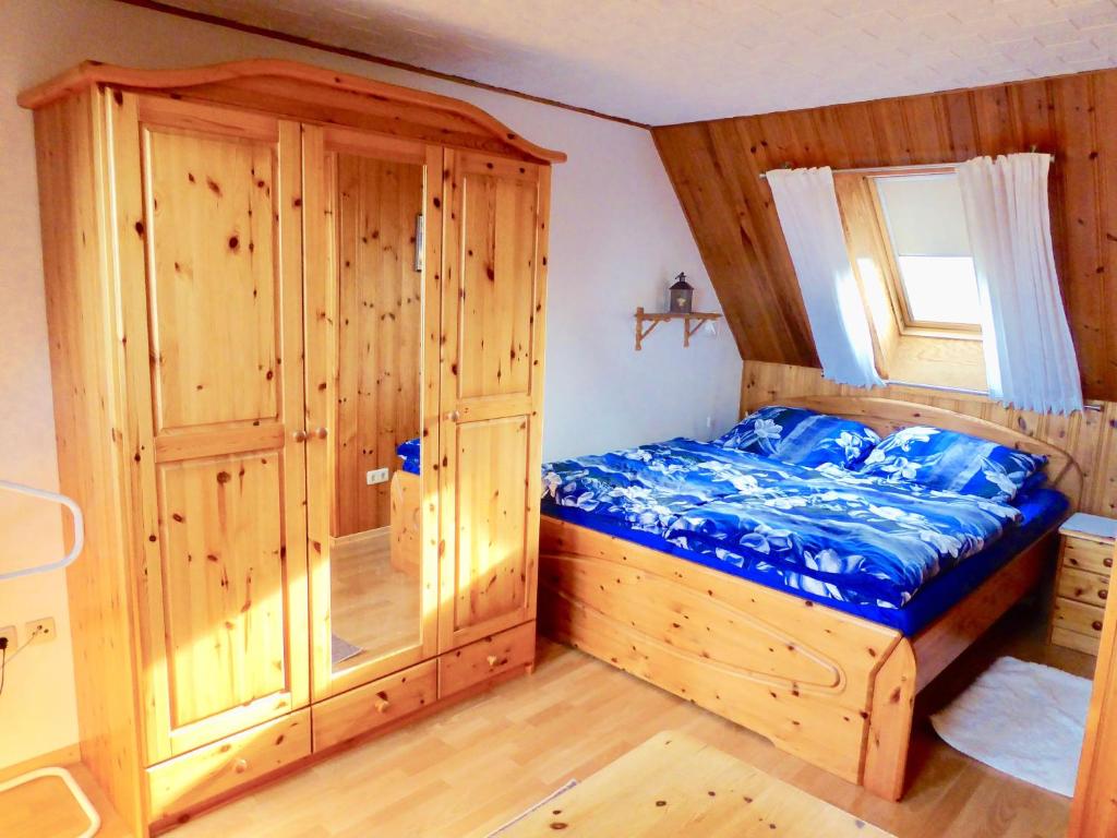 伯格奥夫费马恩Haus-Scheel-2的一间卧室配有一张床和一个木制橱柜