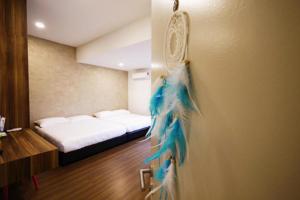 关丹逐梦者酒店的一间设有一张床的房间和一扇带蓝色羽毛的门