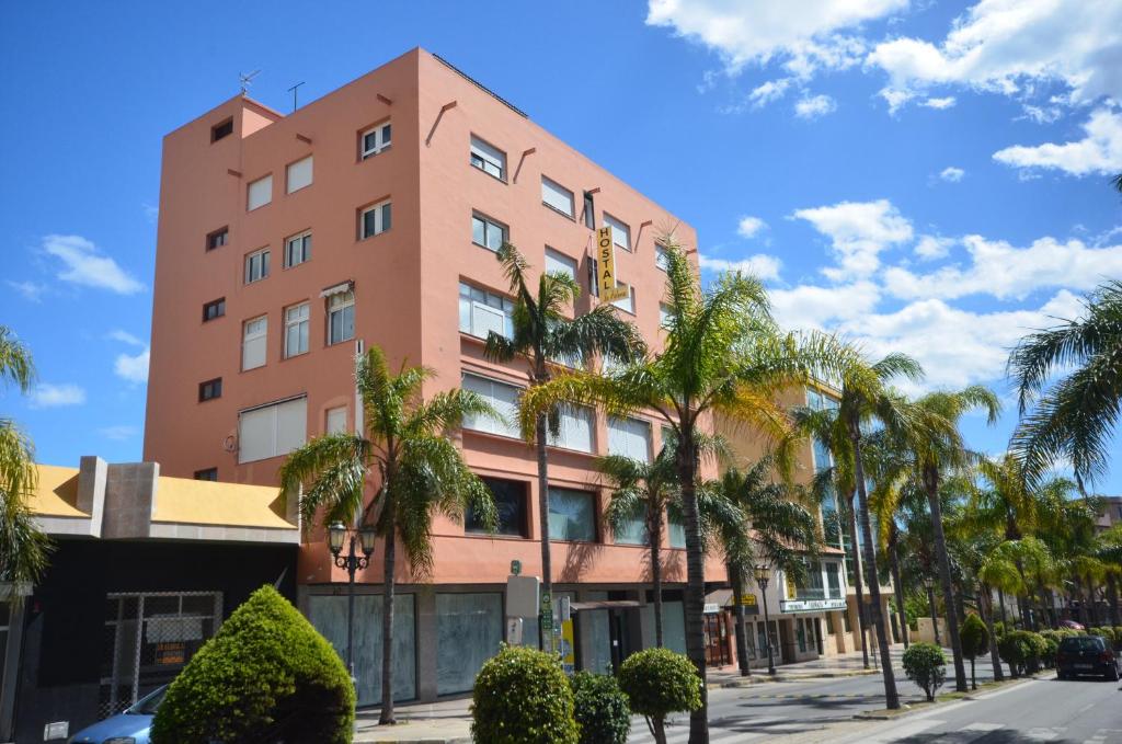 多列毛利诺斯帕尔梅拉旅馆的一座高大的粉红色建筑,前面有棕榈树