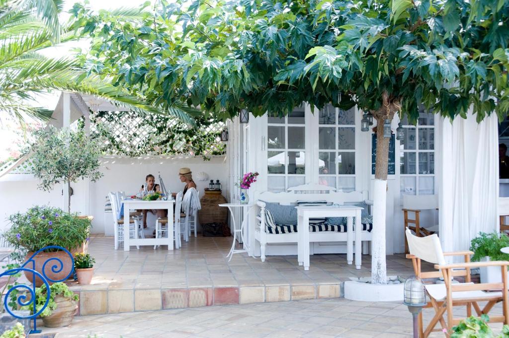 赫索尼索斯Villa Ippocampi - Adults Only的庭院配有白色的桌椅和树木