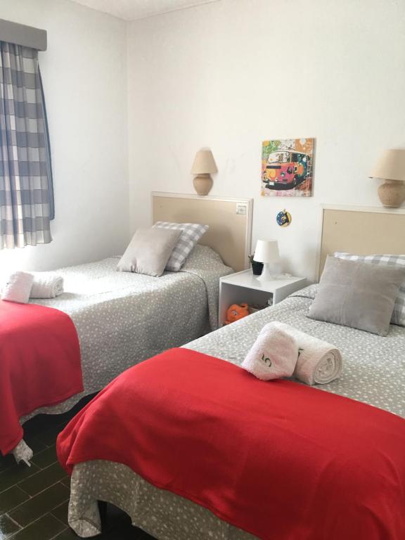 阿尔布费拉Villa Quica, heated pool的一间卧室配有两张红色床单