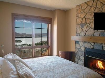 蒙特朗布朗Luxurious Equinoxe Ski-in/Ski-out的一间卧室设有壁炉、一张床和一个窗户。