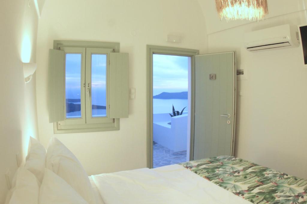 易莫洛林Agave Santorini Design Boutique Hotel的一间卧室设有一张床和一个窗口