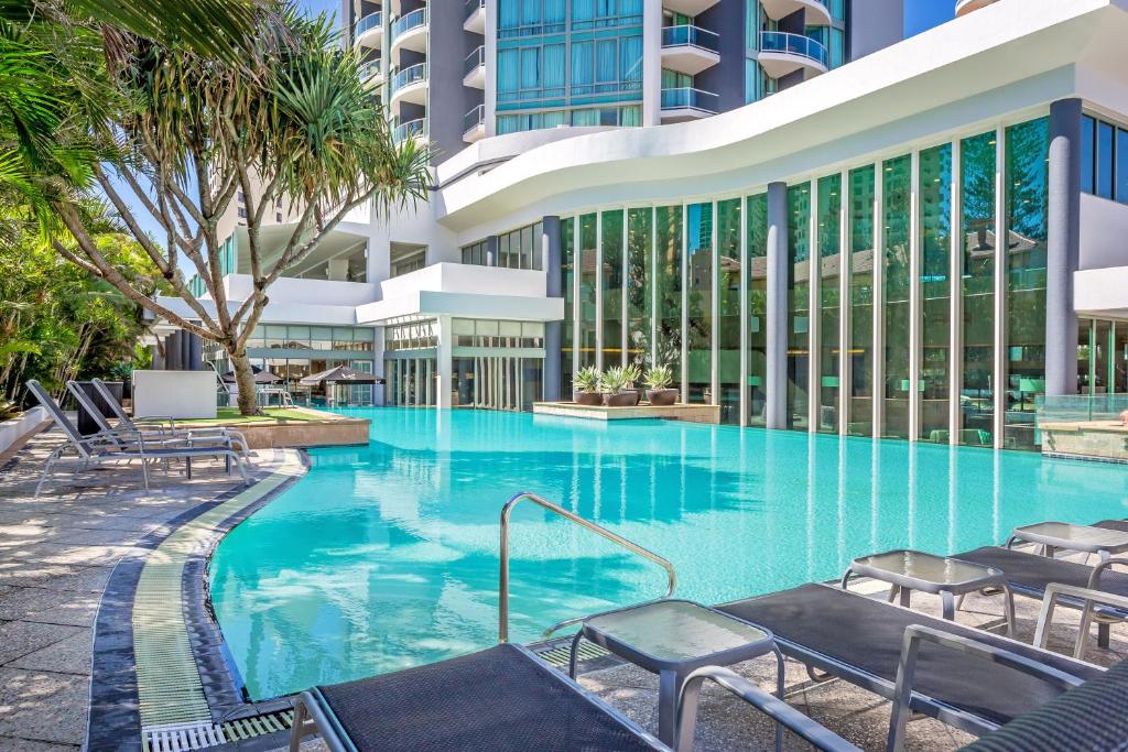 黄金海岸曼特拉传奇酒店的一座带椅子的大型游泳池和一座建筑