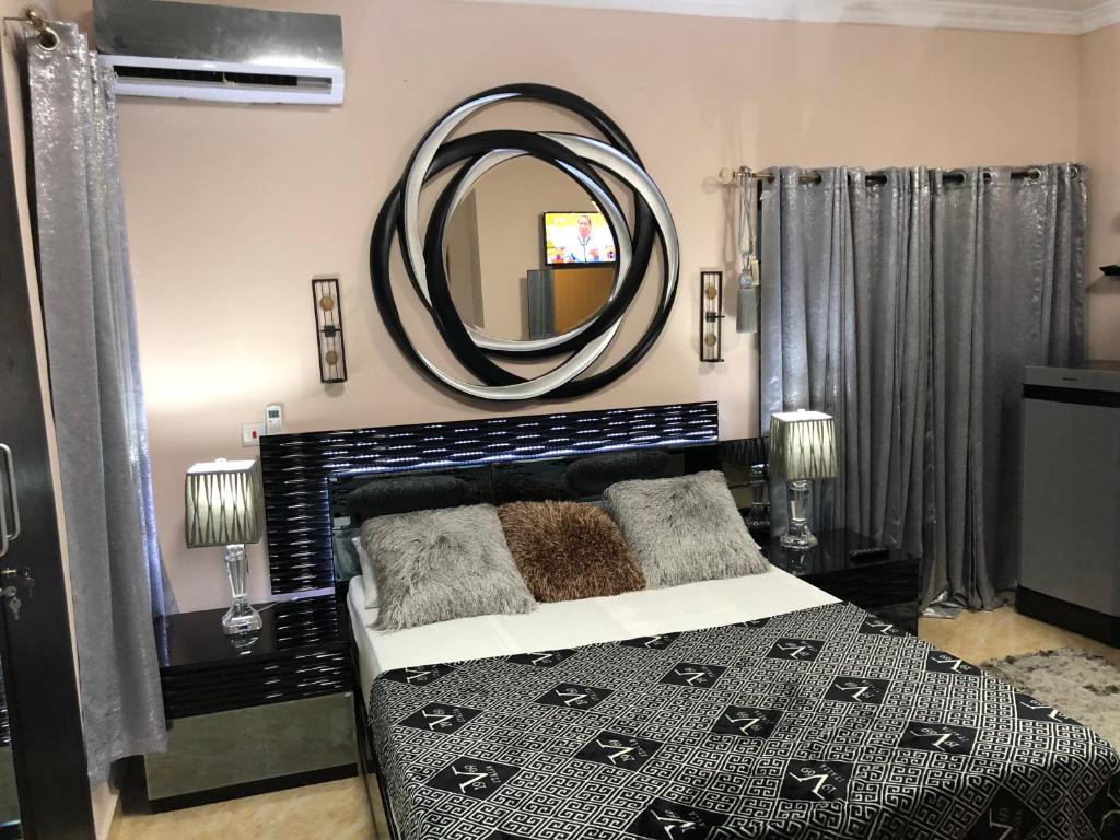 阿克拉Westland Villa的一间卧室配有一张床和一面大镜子