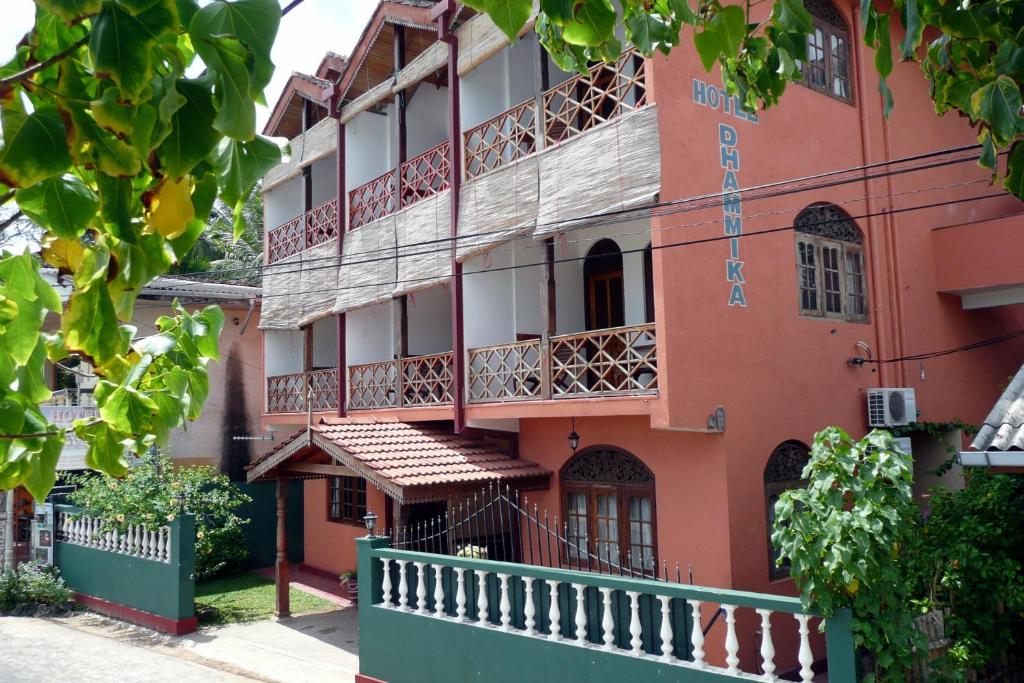 乌纳瓦图纳Hotel Dhammika的一座橙色的建筑,在街上设有阳台